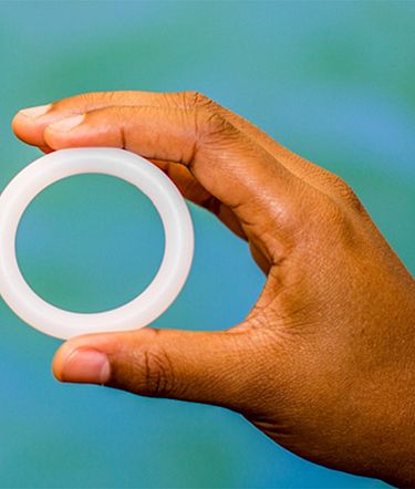 A hand holding a vaginal ring, which can be used to deliver contraceptives, HIV preventatives, and other drugs.